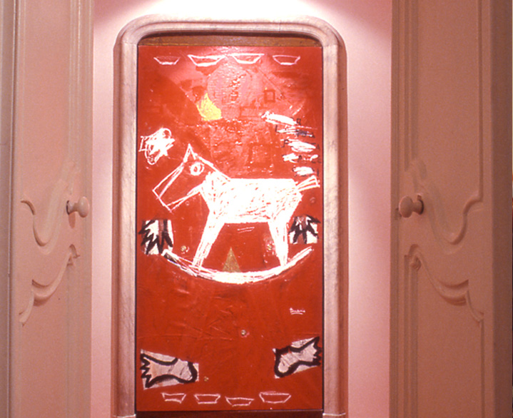 A contemporary red artwork of a horse figure, displayed inside the property